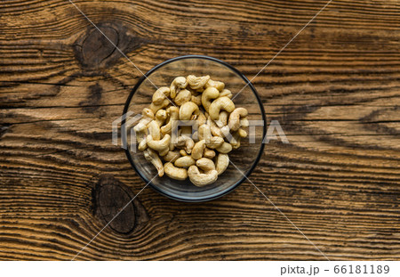 Cashew nuts in a small plate on a vintage wooden table as a background. Cashew nut is a healthy vegetarian protein nutritious food. 66181189
