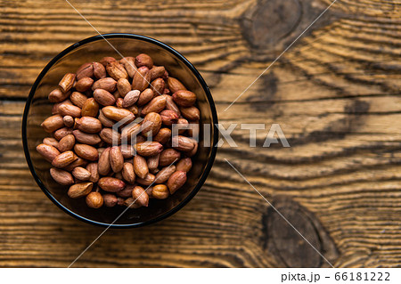 Peanut nuts in a small plate on a vintage wooden table as a background with a copy space.. Peanuts nut is a healthy vegetarian protein nutritious food. 66181222