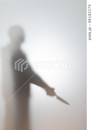 Blurred silhouette of a man with a knife. 66182274