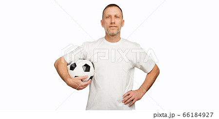 One man holds a soccer ball in akimbo posing. Player isolated on white background One man holds a soccer ball in akimbo posing. Player isolated on white background 66184927
