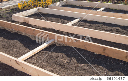 Wooden formwork from new boards for vegetable beds in the garden, preparation and construction, carpentry Wooden formwork from new boards for vegetable beds in the garden, preparation and construction, carpentry 66191437