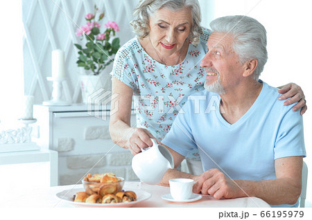 Portrait of mature couple drinking tea with cookies 66195979