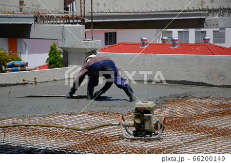MALACCA, MALAYSIA -JUNE 17, 2016: Construction workers levelling the pouring wet concrete on the floor at the construction site. 66200149