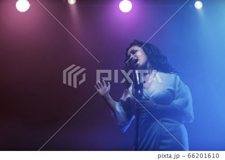 A jazz singer performs on stage. Afro. 66201610