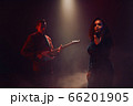A jazz singer and guitarist perform on stage. 66201905