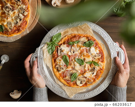 Flat lay with homemade italian pizza, olive oil, tomatoes, meat and cheese on wooden brown table. 66203617
