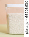 Plastic transparent container with rice on a green background. 66203630