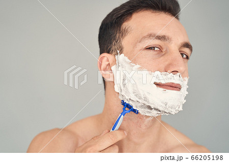 Nice-looking young man disposing of his beard and moustache Nice-looking young man disposing of his beard and moustache 66205198