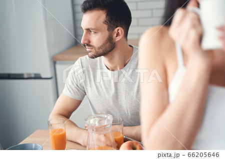 Unhappy tired man having breakfast at home with his wife Unhappy tired man having breakfast at home with his wife 66205646