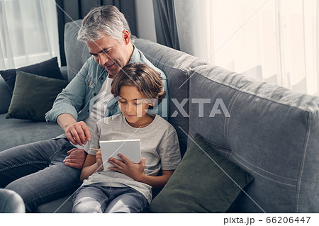 Smiling dad and child sitting at home together 66206447