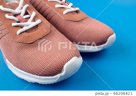 Brown textile sneakers on a blue background. Brown textile sneakers on a blue background. 66206821
