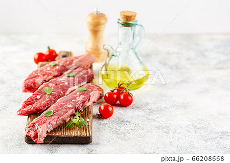 Raw steak with spices on wooden cutting board Raw steak with spices on wooden cutting board 66208668