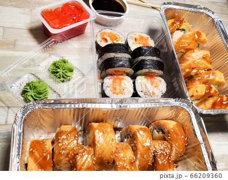 Several boxes with sets of sushi rolls. Takeaway food delivery 66209360
