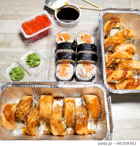 Several boxes with sets of sushi rolls. Takeaway food delivery 66209361