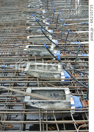 MALACCA, MALAYSIA -APRIL 14, 2016: Pre-stress cable tendons anchor end for pre-stressed concrete at the construction site. It is a technology to get better concrete slab quality with larger span. MALACCA, MALAYSIA -APRIL 14, 2016: Pre-stress cable tendons anchor end for pre-stressed concrete at the construction site. It is a technology to get better concrete slab quality with larger span. 66210735