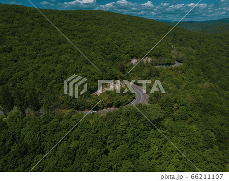 Mountain winding zig zag road. Top aerial view: cars driving on road from above. Mountain winding zig zag road. Top aerial view: cars driving on road from above. 66211107