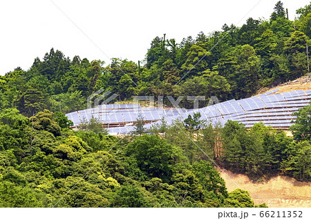 山を削って設置されたメガソーラーと緑の木々 工事途中の写真素材