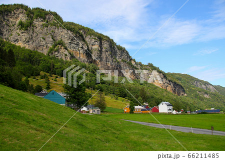 ノルウェー　ベルゲンからハダンゲルフィヨルドに至る道筋の観光スポット、スタインダールの滝から望む民家 66211485