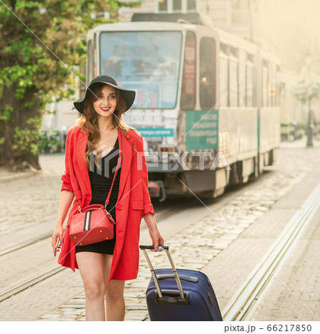 Beautiful young girl walking with blue suitcase. Beautiful young girl walking with blue suitcase. 66217850
