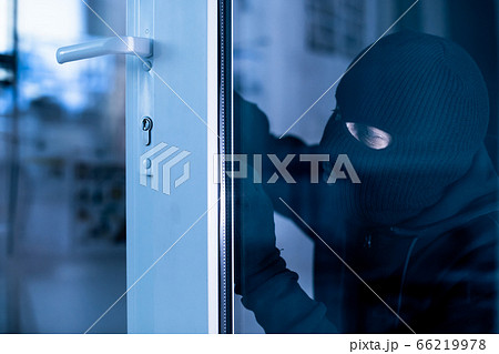 Robber in black balaclava cracking door with metal picklock Robber in black balaclava cracking door with metal picklock 66219978