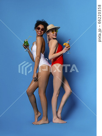 Beautiful Young Girls In Swimsuits Holding Summer Cocktails And Smiling At Camera Beautiful Young Girls In Swimsuits Holding Summer Cocktails And Smiling At Camera 66220358