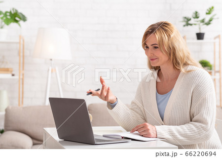 School, college and university online. Smiling female teacher holds lessons on laptop School, college and university online. Smiling female teacher holds lessons on laptop 66220694