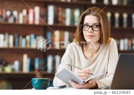 Dreamy young journalist creating article writing ideas in notebook Dreamy young journalist creating article writing ideas in notebook 66220695