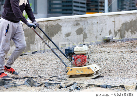 The builder compacts crushed stone with a gasoline The builder compacts crushed stone with a gasoline 66230888