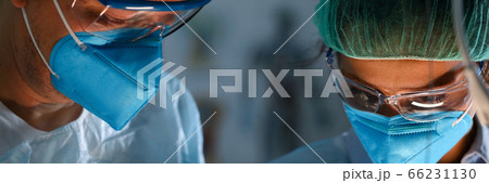 Surgeon and anastasiologist in uniform look down Surgeon and anastasiologist in uniform look down 66231130