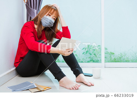 sad woman hug her knee and cry wearing face mask 66233019