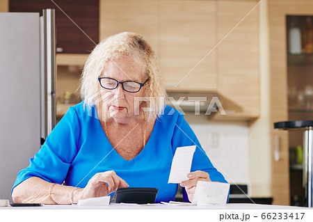 Senior woman handles bookkeeping 66233417