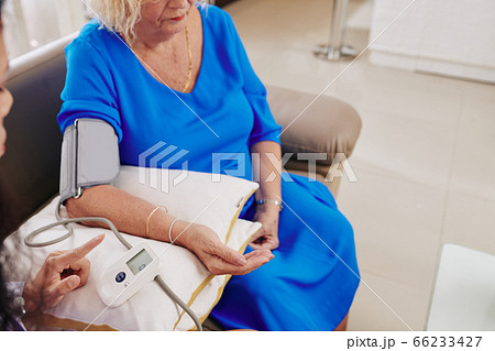 General practitioner checking blood pressure of patient General practitioner checking blood pressure of patient 66233427