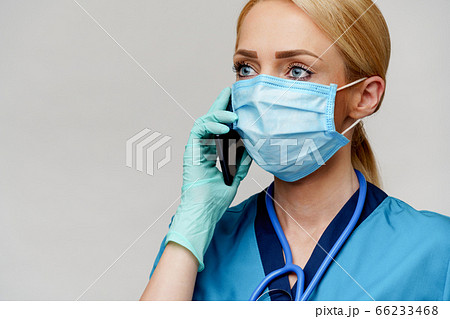 medical doctor nurse woman with stethoscope wearing protective mask and rubber or latex gloves talking on mobile cell phone 66233468