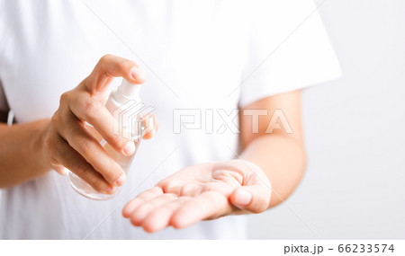 woman applying spray pump dispenser sanitizer woman applying spray pump dispenser sanitizer 66233574