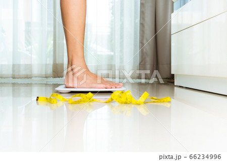 Female leg is standing on white scales at home Female leg is standing on white scales at home 66234996