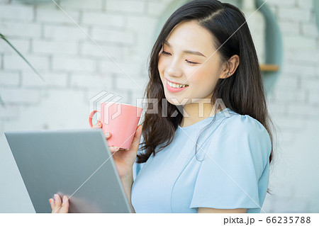 A beautiful woman using laptop while drinking cafe 66235788
