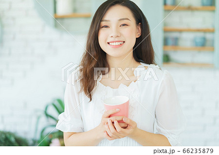 Beautiful woman holding a cup Beautiful woman holding a cup 66235879