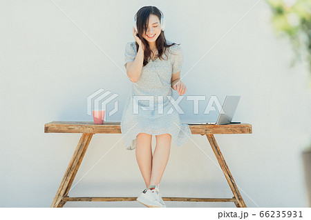 A beautiful woman wearing head phone and using laptop A beautiful woman wearing head phone and using laptop 66235931