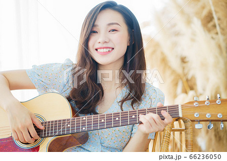 Beautiful woman playing guitar at home 66236050