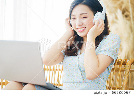 Beautiful woman wearing headphone and using laptop at home 66236067