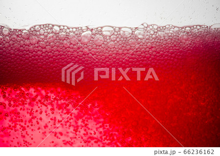 Background of close-up soda bubbles mixed with red fruit juice on white background. 66236162