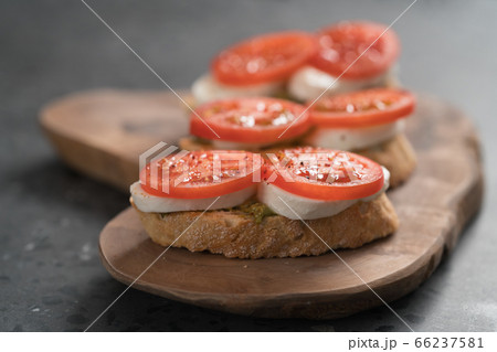 Bruschetta with tomatoes, mozzarella and pesto on olive wood board Bruschetta with tomatoes, mozzarella and pesto on olive wood board 66237581