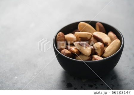 brazil nuts in black bowl on concrete background with copy space 66238147
