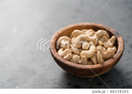 Dry cashew nuts in wood olive bowl on concrete background with copy space 66238163