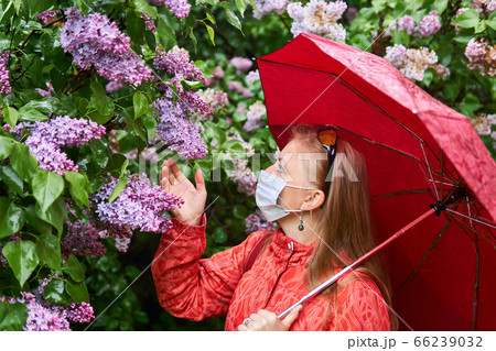 woman in a surgical protective mask tries to smell 66239032