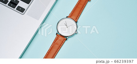 Wristwatch, laptop on empty blue background, top view Wristwatch, laptop on empty blue background, top view 66239397