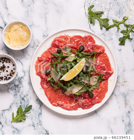 Marbled beef carpaccio with arugula, capers, lemon Marbled beef carpaccio with arugula, capers, lemon 66239451