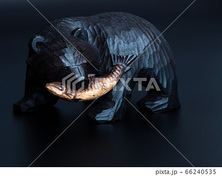 鮭を口に咥えた木彫りの熊　黒背景 66240535