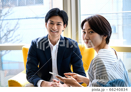 オフィスで打ち合わせするビジネスカジュアルの男女 66240834