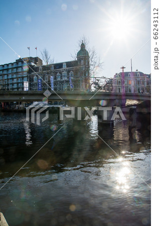 オランダアムステルダムの街並み 運河沿いに並ぶレンガ造りの歴史的な建物に注ぐまぶしい太陽 オランダアムステルダムの街並み 運河沿いに並ぶレンガ造りの歴史的な建物に注ぐまぶしい太陽 66243112